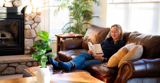 woman sitting on couch reading a book
