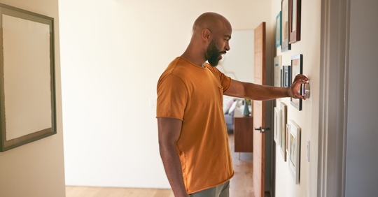 man setting thermostat