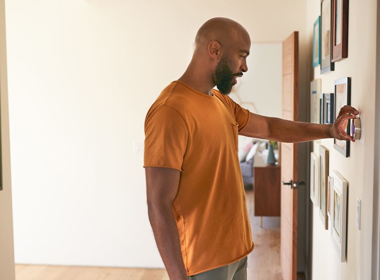 man setting thermostat